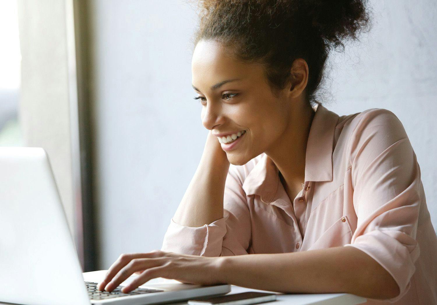woman smiling while on her laptop