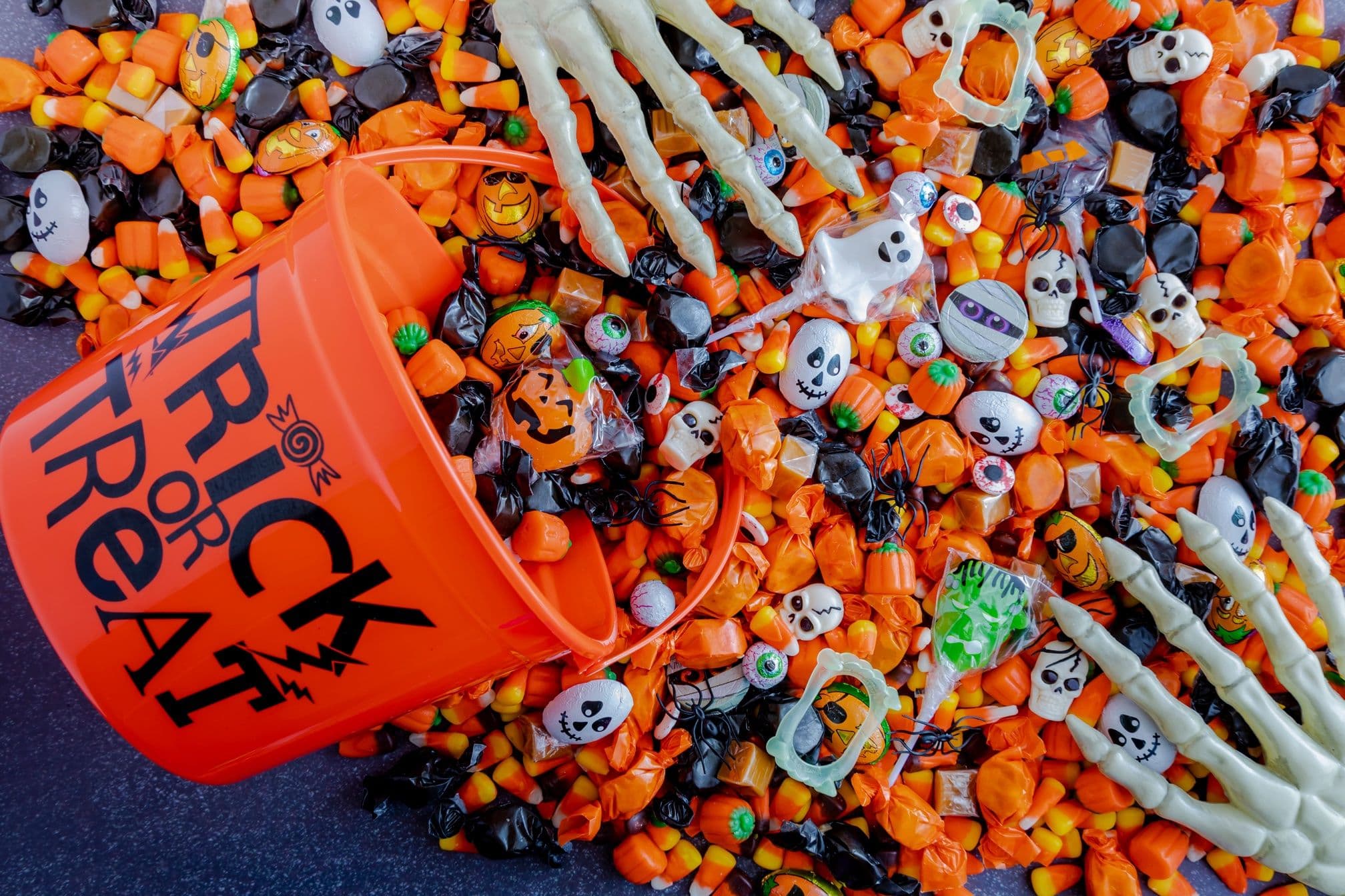 halloween candy pouring out of a trick or treat bucket