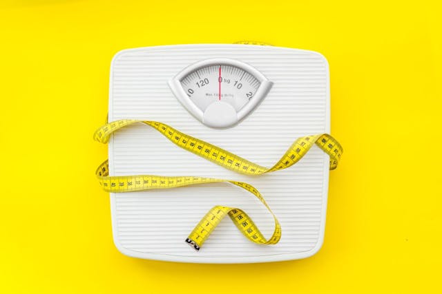 scale and measuring tape on yellow background